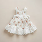 Mona & Milo Lola cotton floral dress displayed on a hanger with vibrant flower print and flowing fabric.