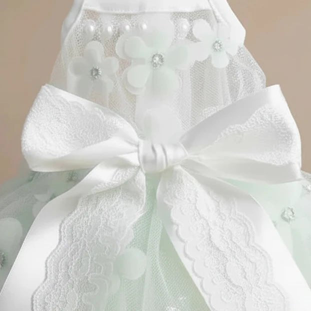 Close-up of Jolie small dog tulle lace dress — white satin bow detail with star and flower lace pattern on layered skirt