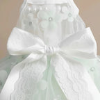 Close-up of Jolie small dog tulle lace dress — white satin bow detail with star and flower lace pattern on layered skirt
