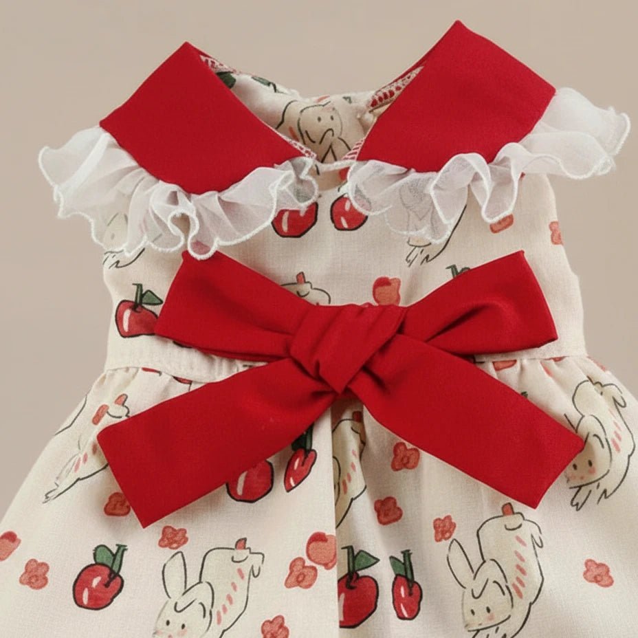 Mona & Milo Marmalade cotton dress shown on a hanger with a vibrant orange and white floral pattern, sleeveless design.