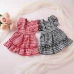 Two checkered dog dresses, one red and one black and white- Mona & Milo